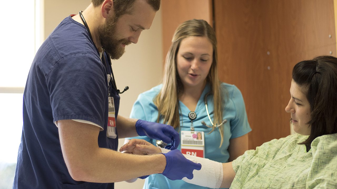 Two nurses wrapping a patients arm